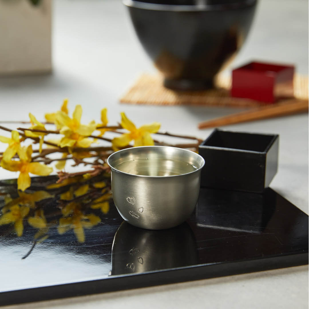 “Hana” Tin Guinomi Cup (With Flower Detail), on a table