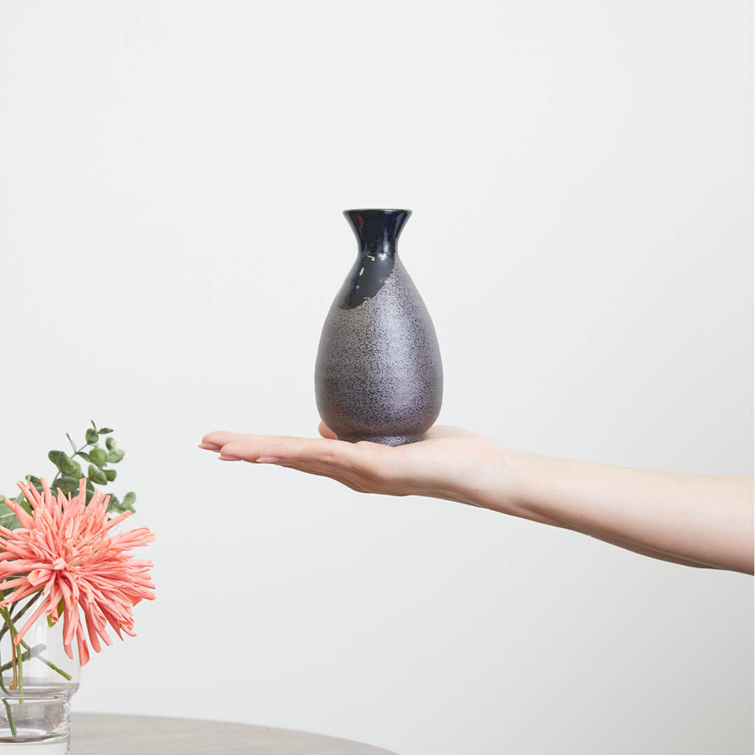 “Mino no Takumi” Black With Blue Drip Glaze and Gold Interior Sake Set, on a hand