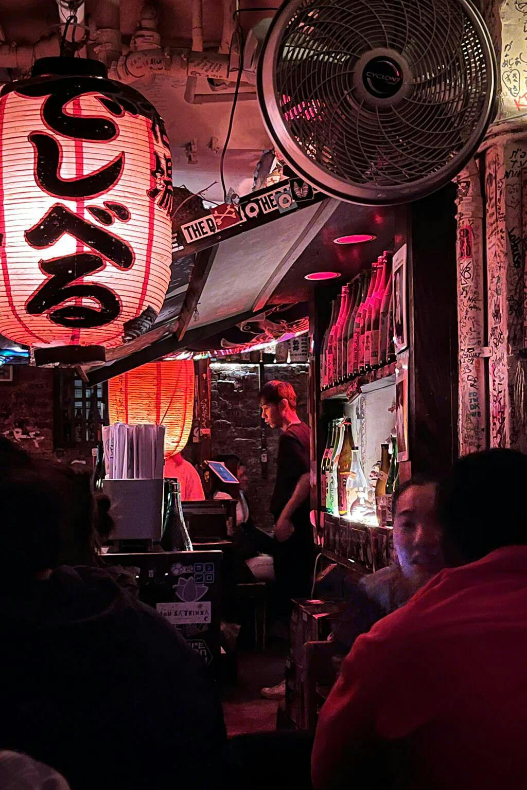 Sake Bar Decibel evokes the unique dive bar scene in Shinjuku, Tokyo, with its graffiti-laden walls and red paper lanterns, which read “でしべる” (“Deshiberu,” or Decibel). | Photo by Taylor Markarian.