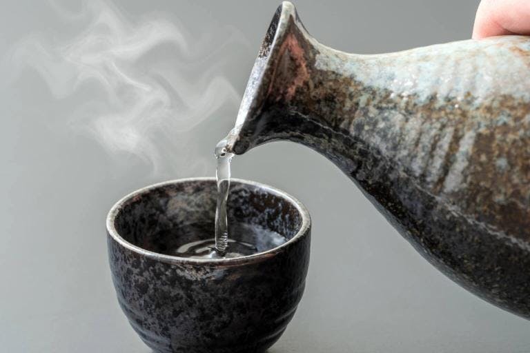 Hot sake is pouring into ochoko