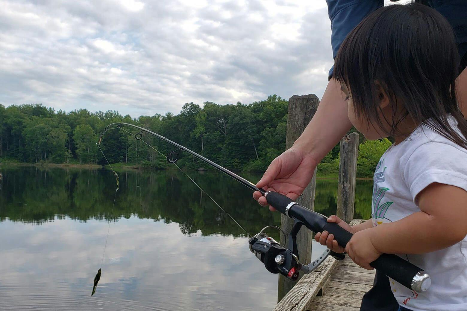 Little girl fishing with father