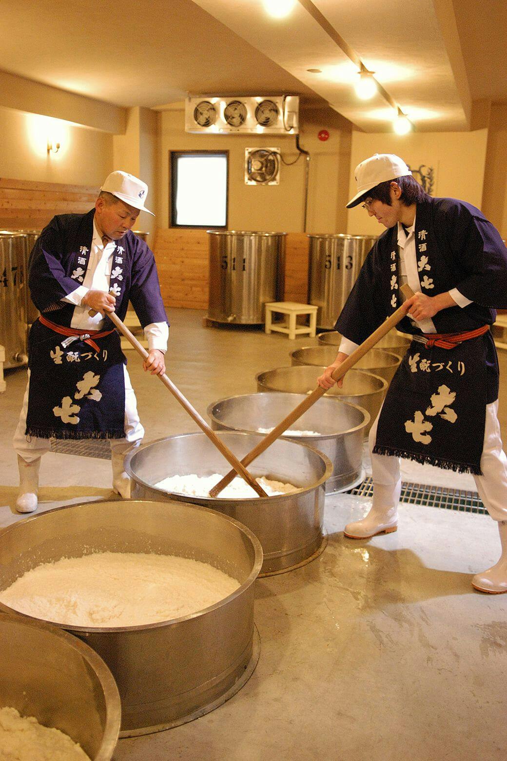 Kurabito (brewery workers) pounding the mash with long oar-shaped paddles