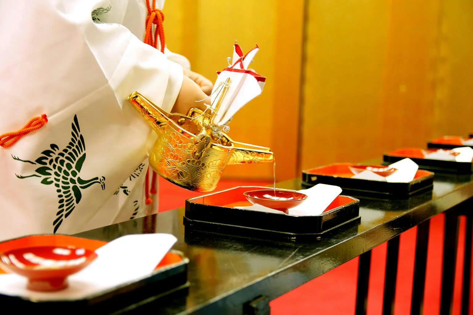 A “miko” (shrine maiden) pours sake to offer to the gods.