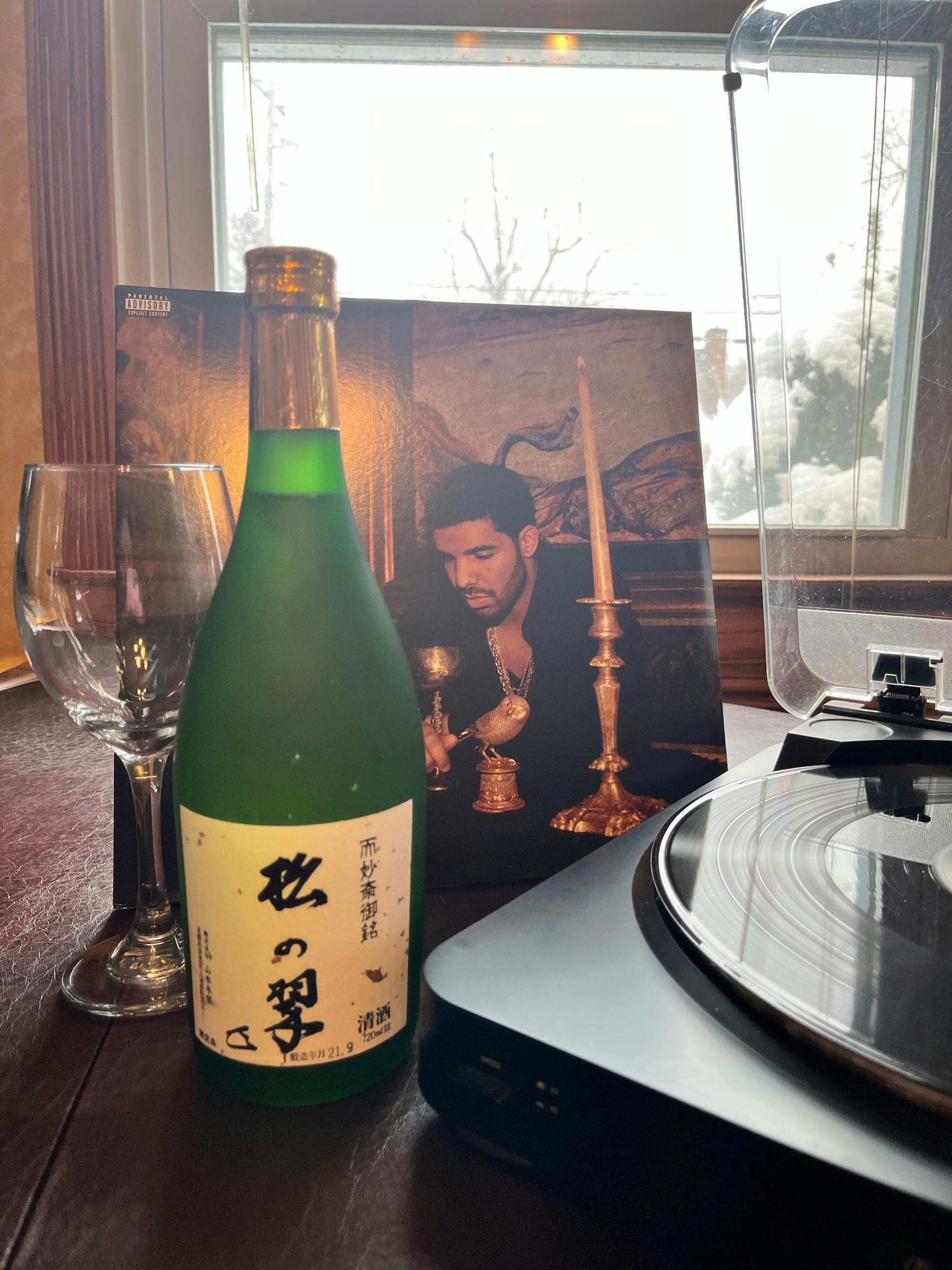 Matsu no Midori “Junmai Daiginjo” in front of “Take Care” vinyl record by Drake. Song playing: “Crew Love” feat. The Weeknd.