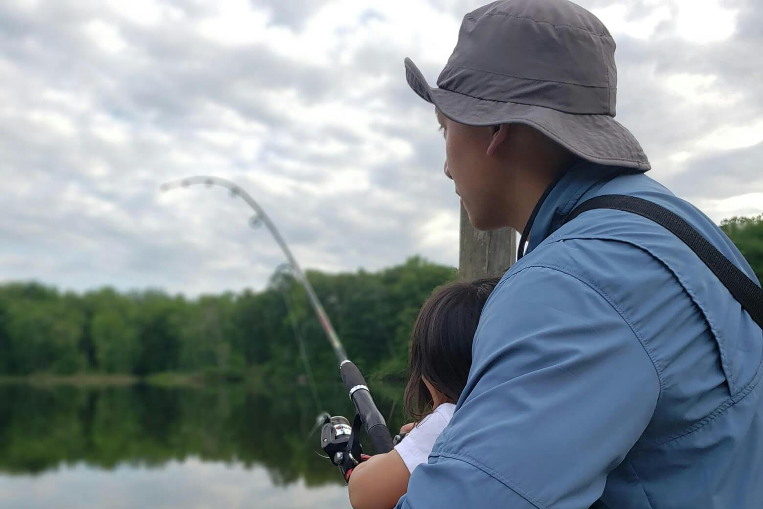 Father fishing with little girl