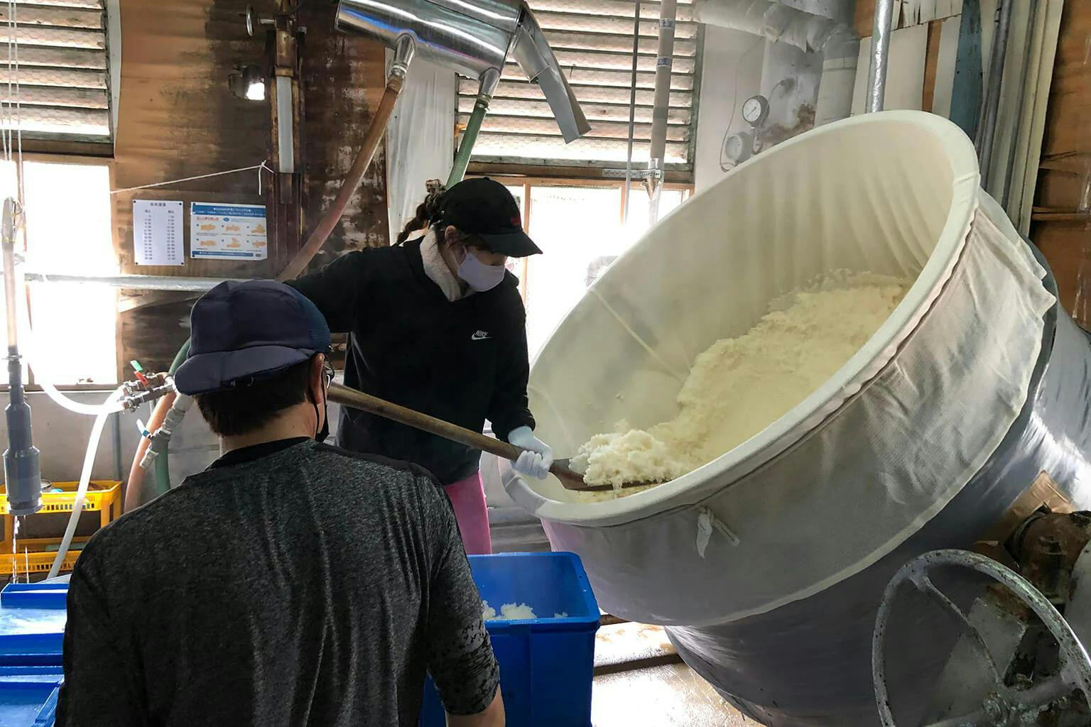 Rina shovels freshly steamed rice out of its tank. | Photo by Azusa K.