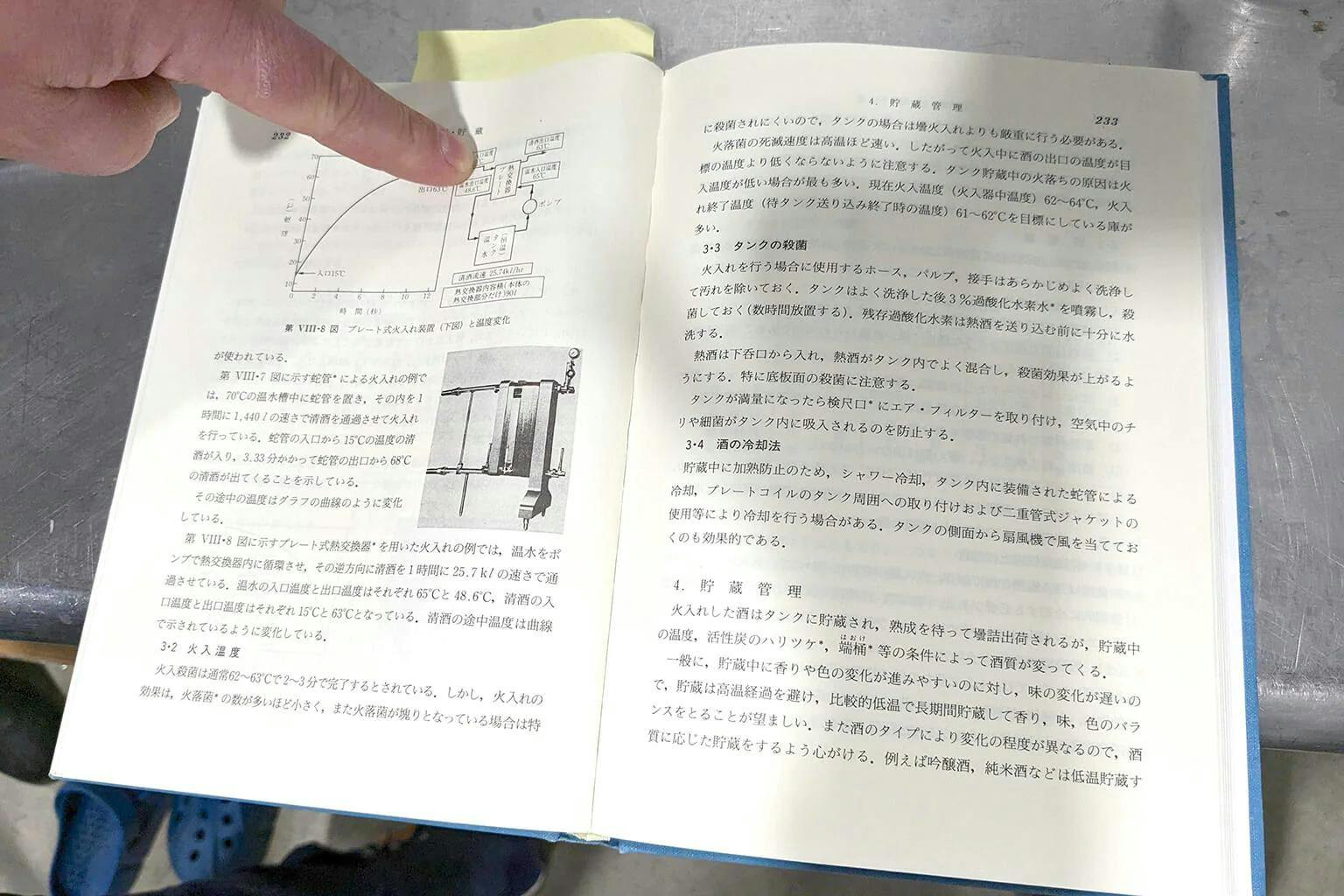 Bellomy points to a diagram in one of his Japanese technical books on sake brewing. | Photo by Sachiko Miyagi.