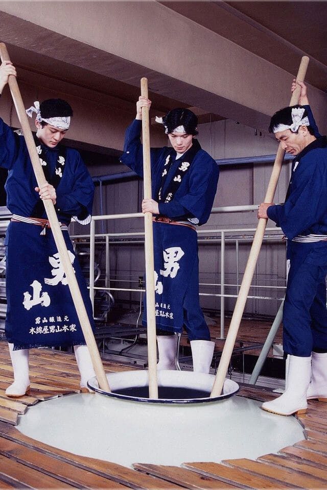 Otokoyama brewery workers use poles to stir the sake mash