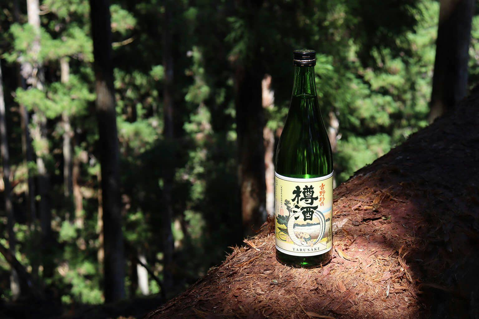 A bottle of Choryo “Yoshinosugi no Taru Sake” with a background of Japanese cedar forest in Nara Prefecture.