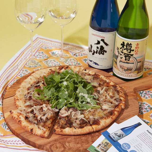 Hakkaisan “Tokubetsu Junmai” and Choryo “Yoshinosugi no Taru Sake” Futsushu with chardonnay glasses, served with gourmet pizza