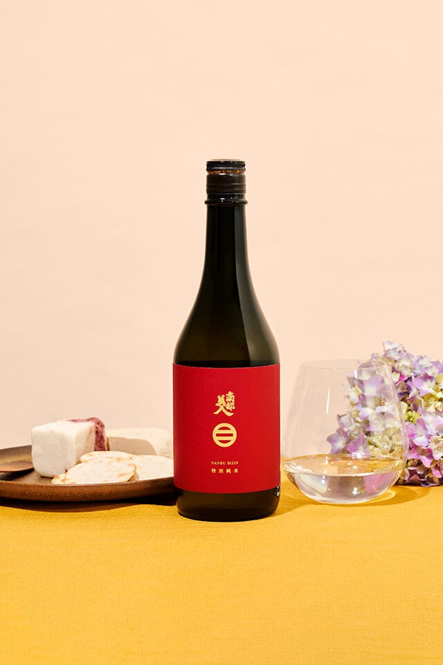 Nanbu Bijin “Tokubetsu Junmai” with a stemless wine glass, served with cheese