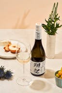 Dassai “39” Junmai Daiginjo with a wine glass, served with cheese and fruits